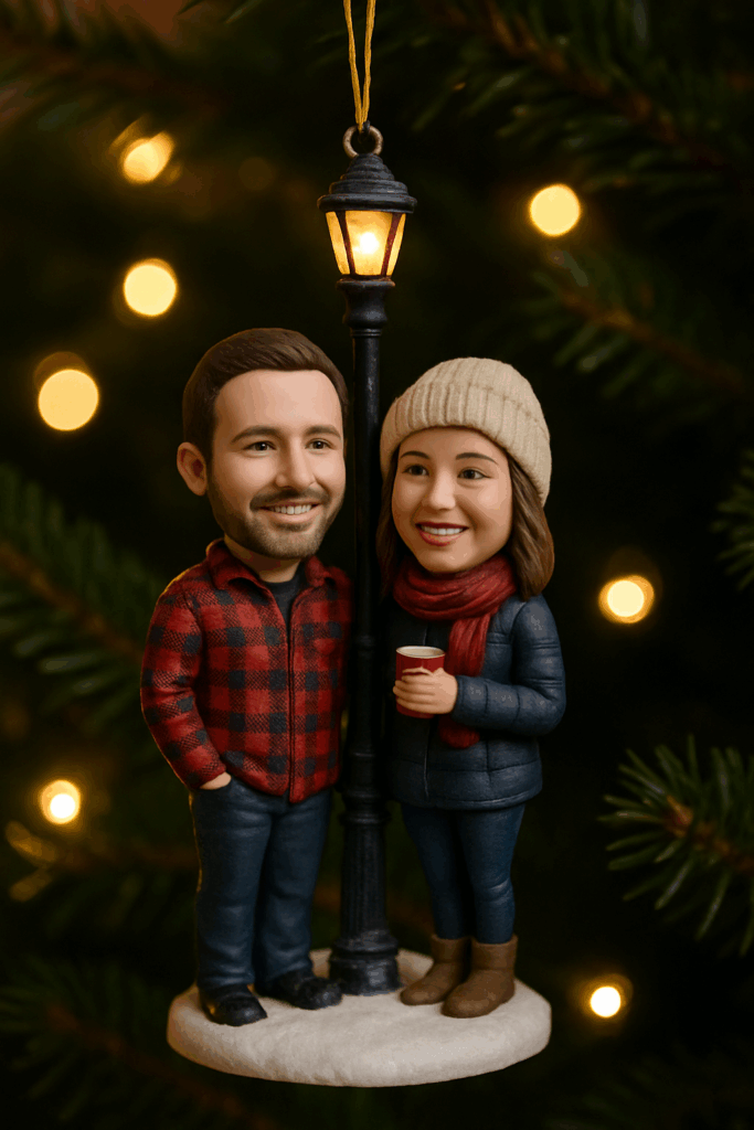 Young couple admiring a personalized bobblehead ornament of their first date under a streetlamp, hanging on a Christmas tree.
