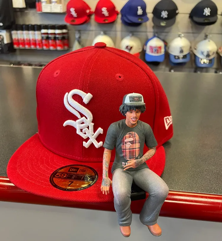 Custom wearable collectible figurine attached to a red streetwear cap